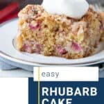 slice of rhubarb cake on a white plate, topped with whipped cream.