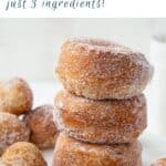 stack of biscuit donuts next to donut holes on a white platter.