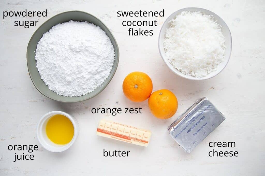 ingredients for orange cream cheese icing on a white table.