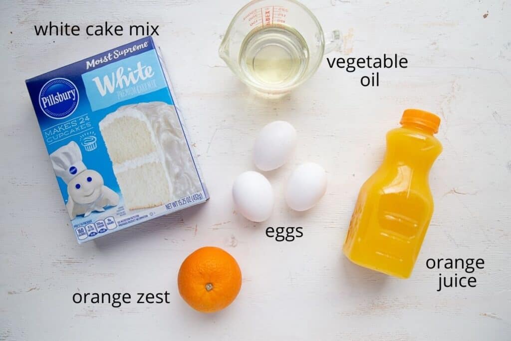 ingredients for orange cake on a white table.