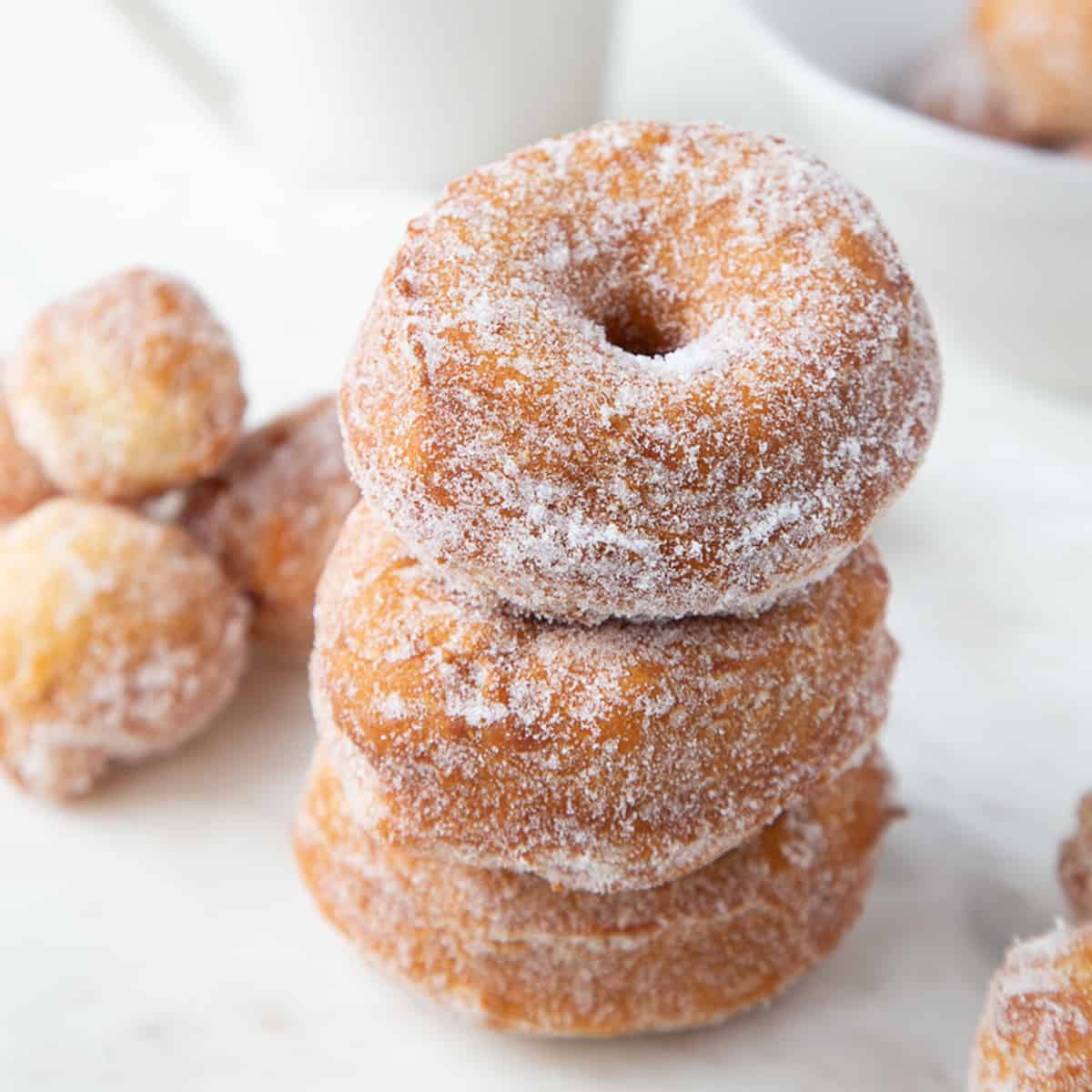 three biscuit donuts rolled in sugar and stacked on top of one another.
