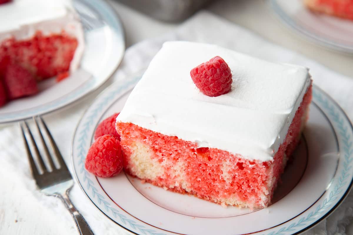 slice of old fashioned poke cake on a blue and white china plate.