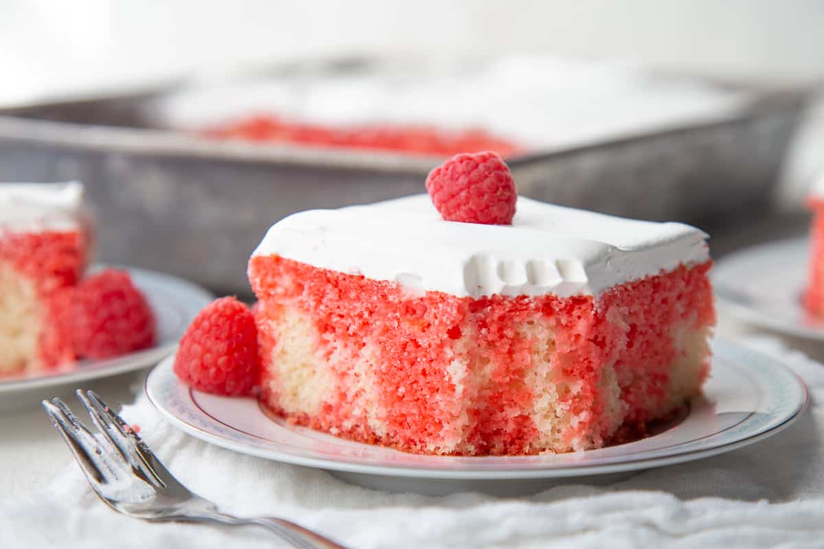 red jello poke cake with a bite taken out.