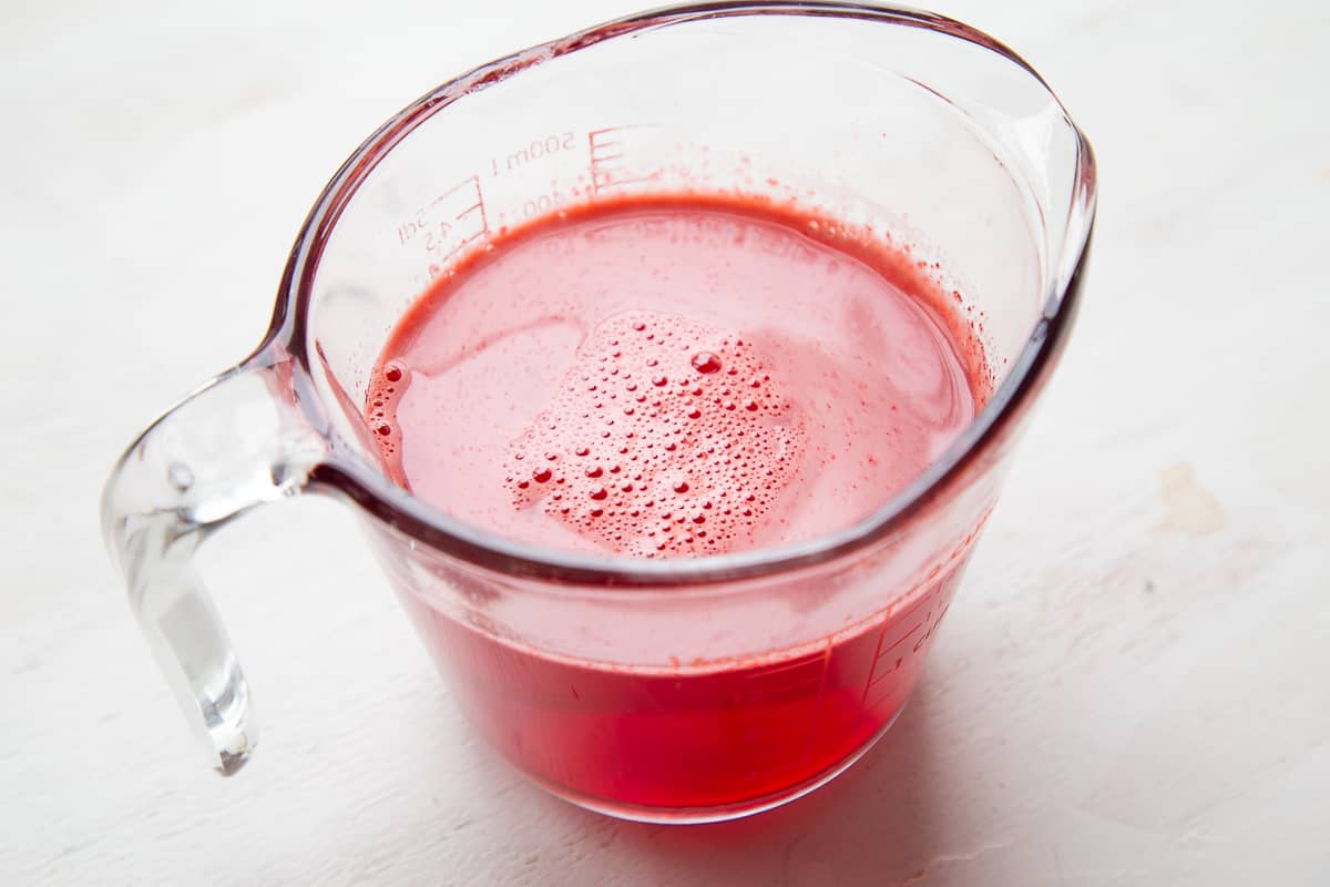 glass measuring cup with red liquid.