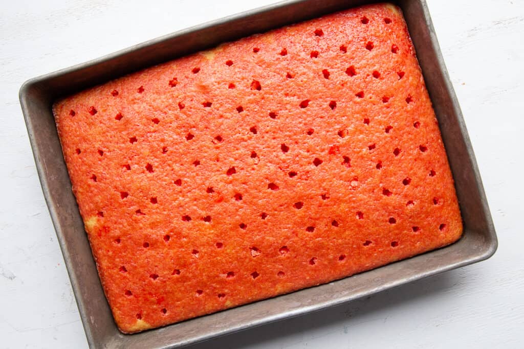 red poke cake with holes in a 9x13 inch pan.