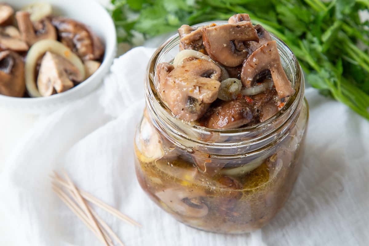 glass mason jar filled with italian marinated mushrooms.