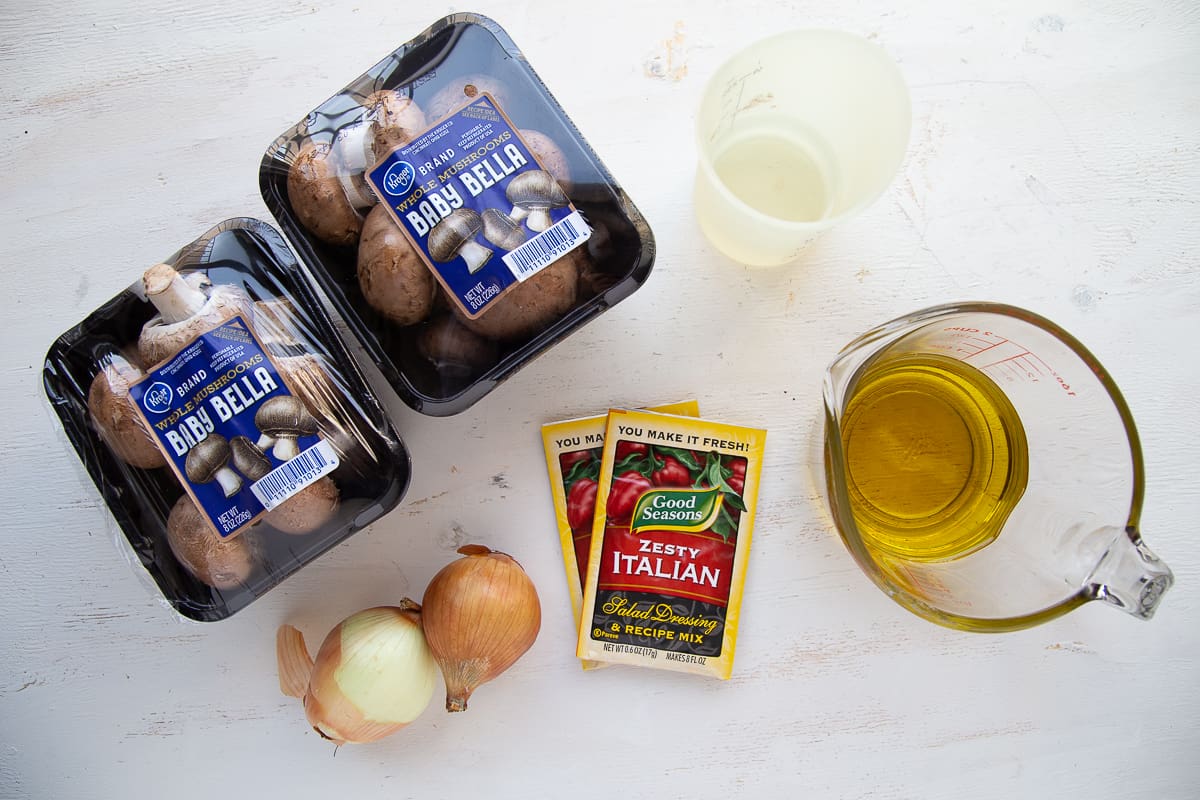 ingredients for marinated mushrooms on a white table.