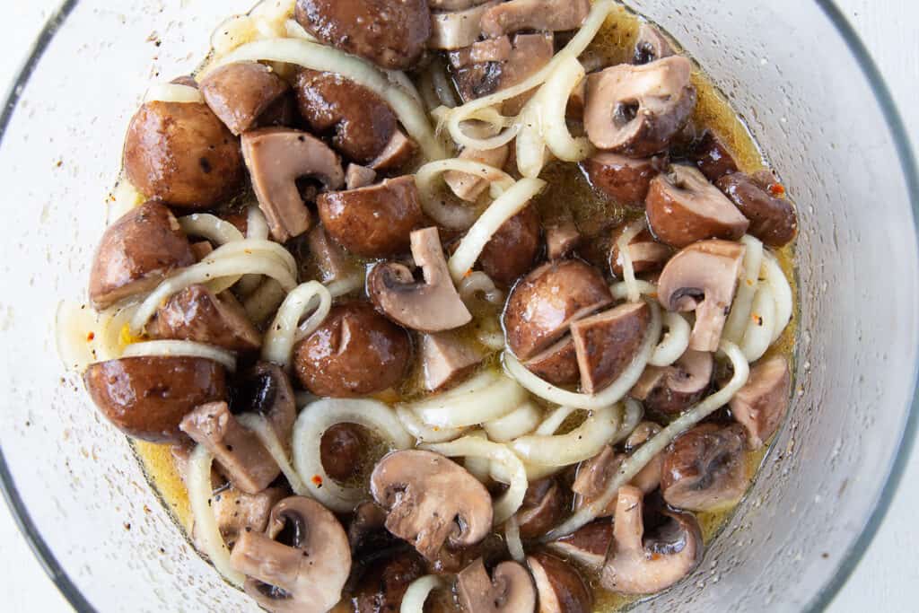 marinated mushrooms and onions in a glass dish.