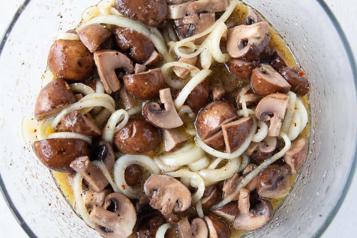 marinated mushrooms and onions in a glass dish.