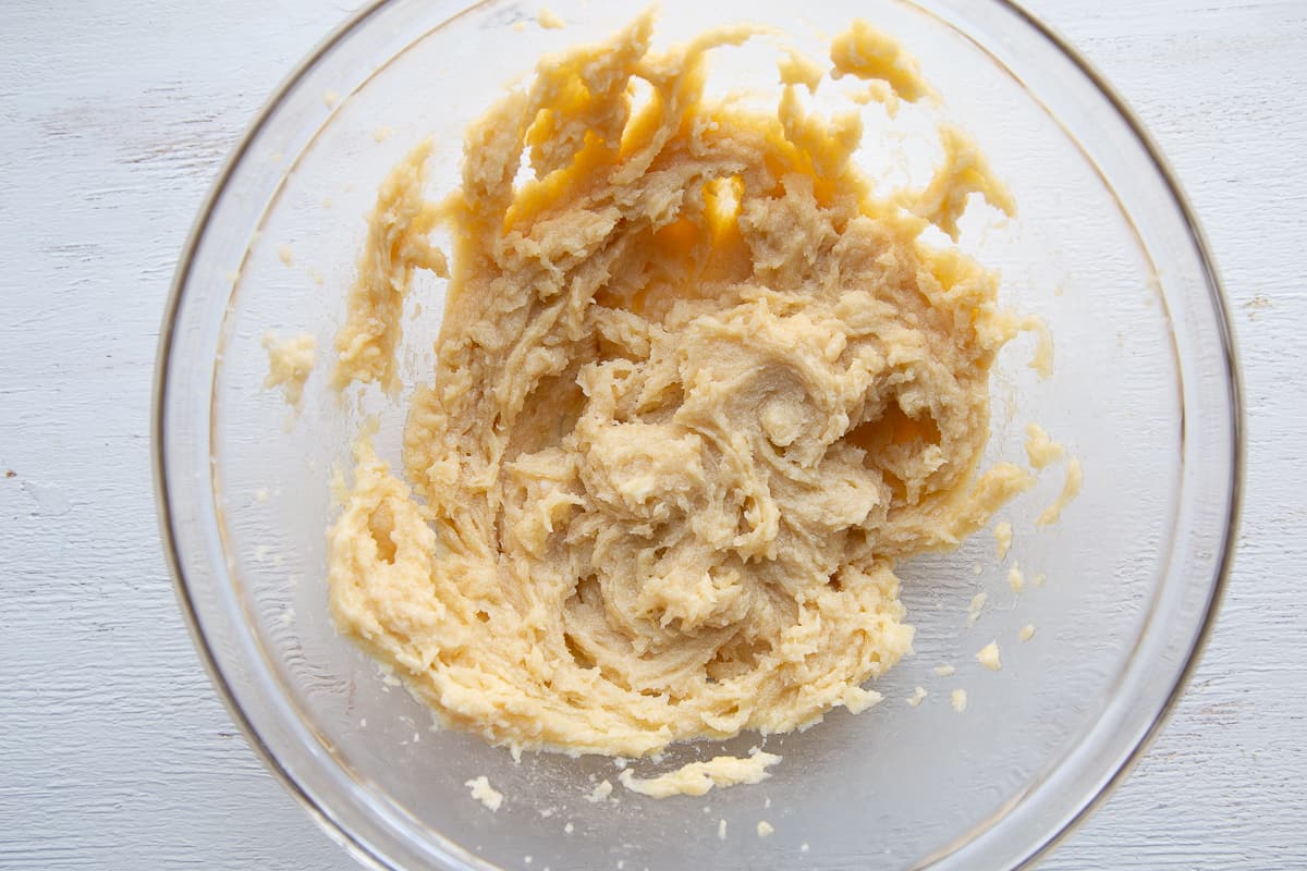butter and sugar creamed together in a glass mixing bowl.