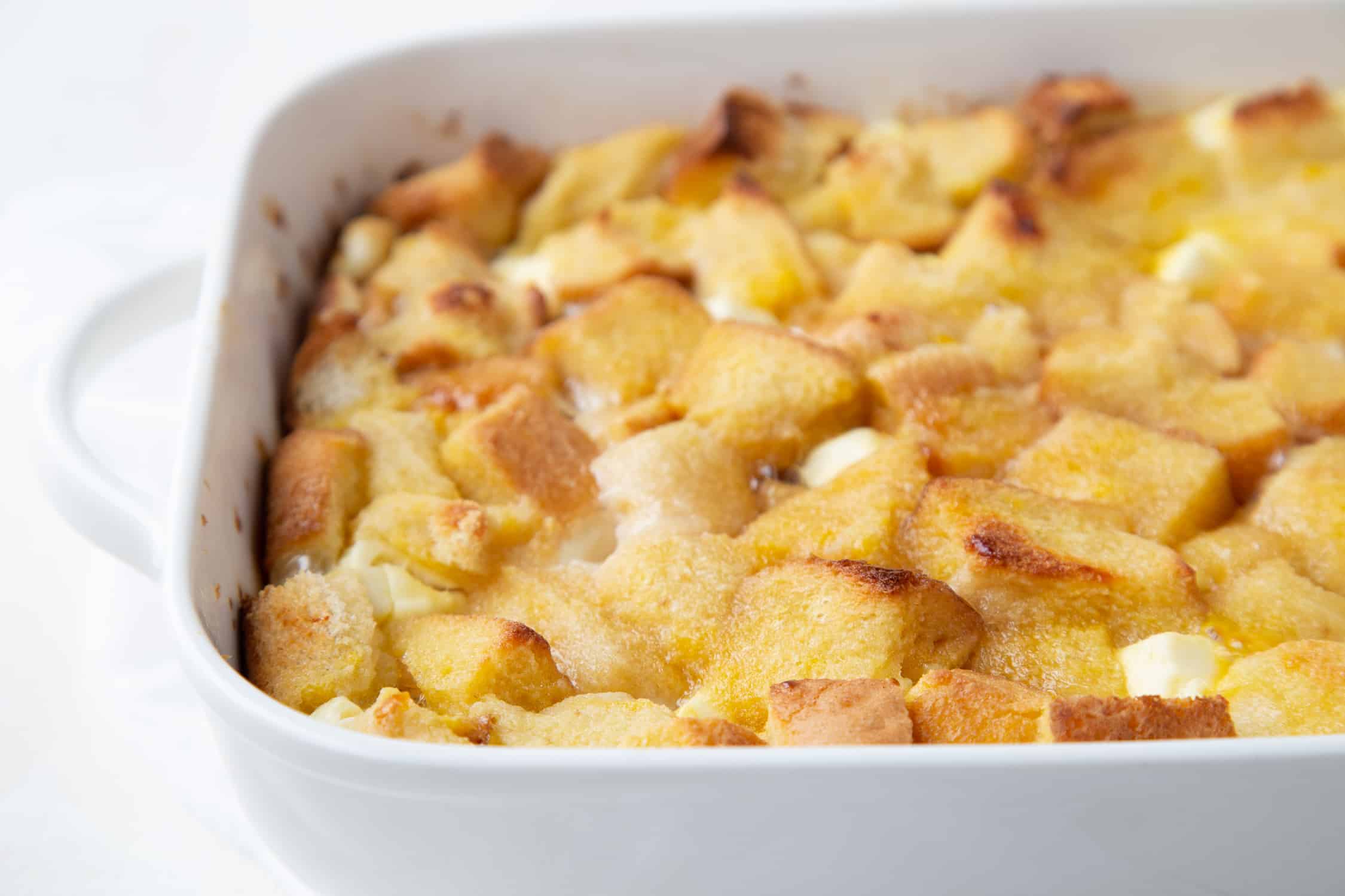 baked stuffed french toast in a white casserole dish with handles.