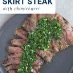 skirt steak on a gray plate, topped with chimichurri.