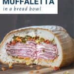 gigantic muffaletta on a wooden board.