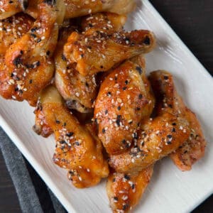 sweet and spicy baked wings on a rectangular white serving platter.