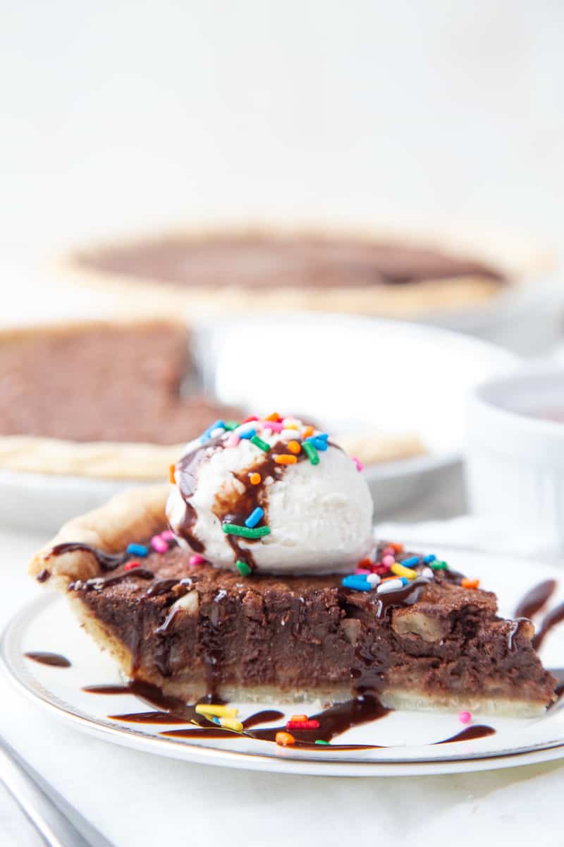 slice of brownie pie topped with ice cream and sprinkles.