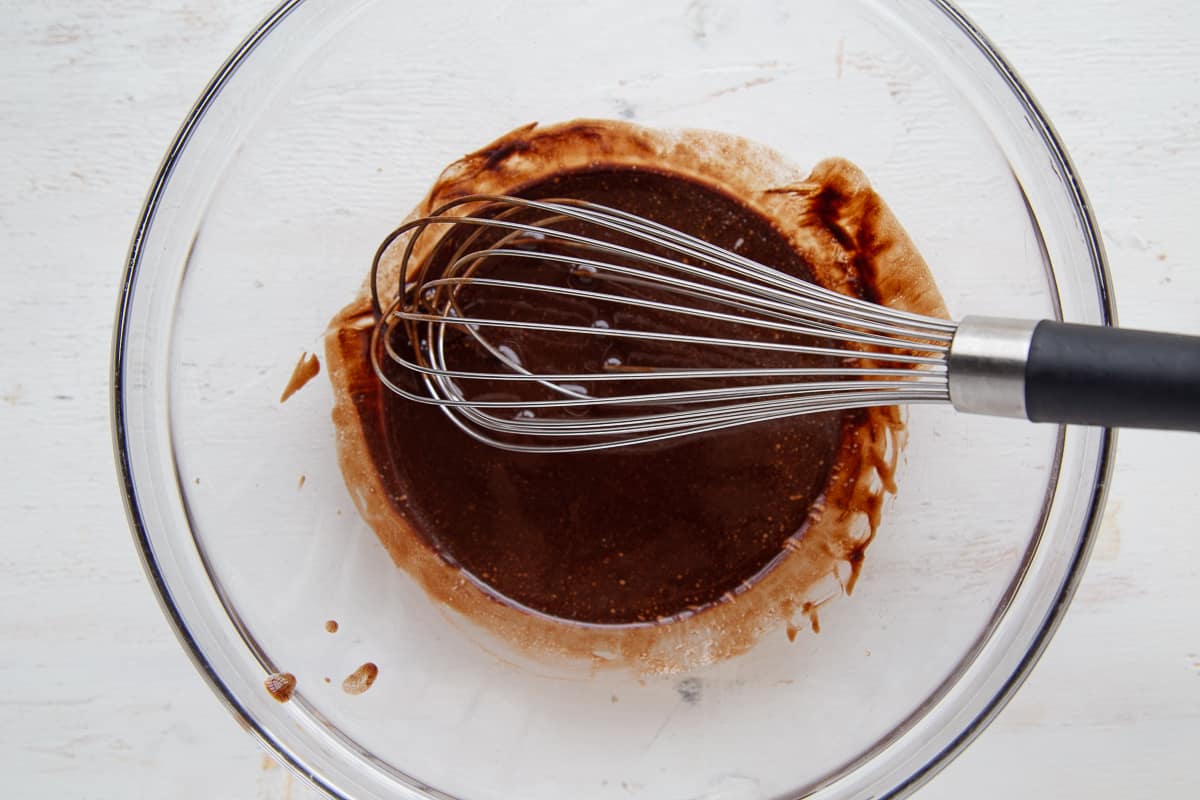 melted butter and chocolate with a whisk in a glass bowl.