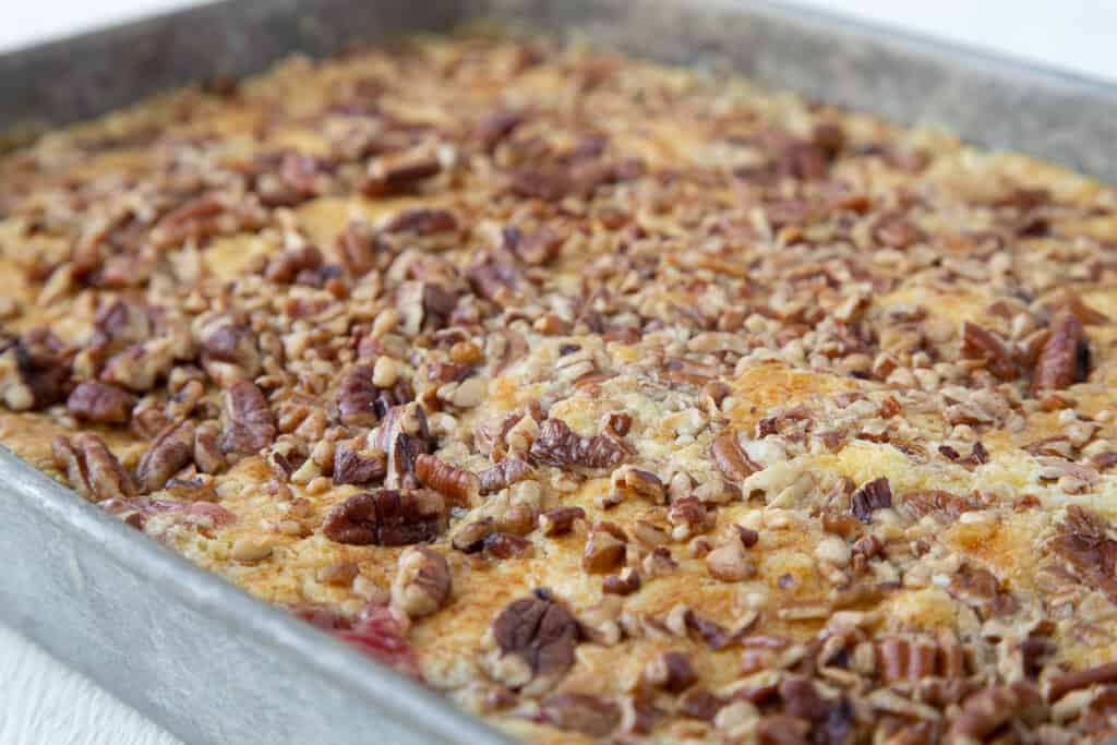 cherry dump cake with pecans in a metal pan.