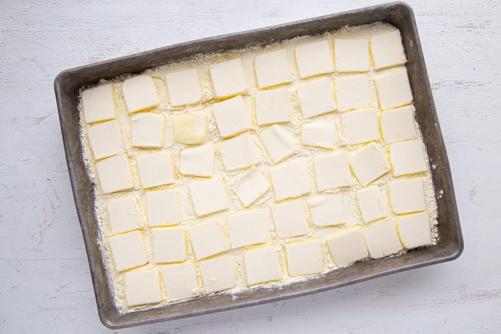butter slices on top of dry cake mix in a metal pan.
