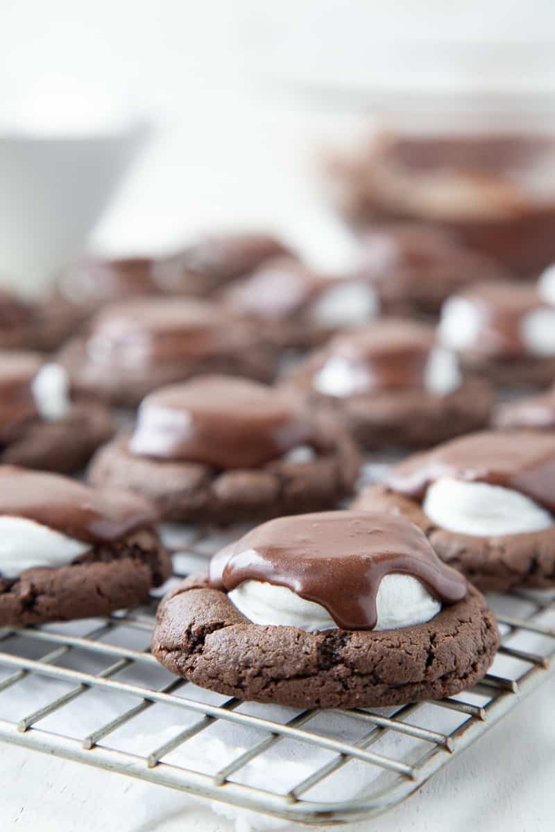 chocolate marshmallow cookies topped with fudge frosting on a wire rack.