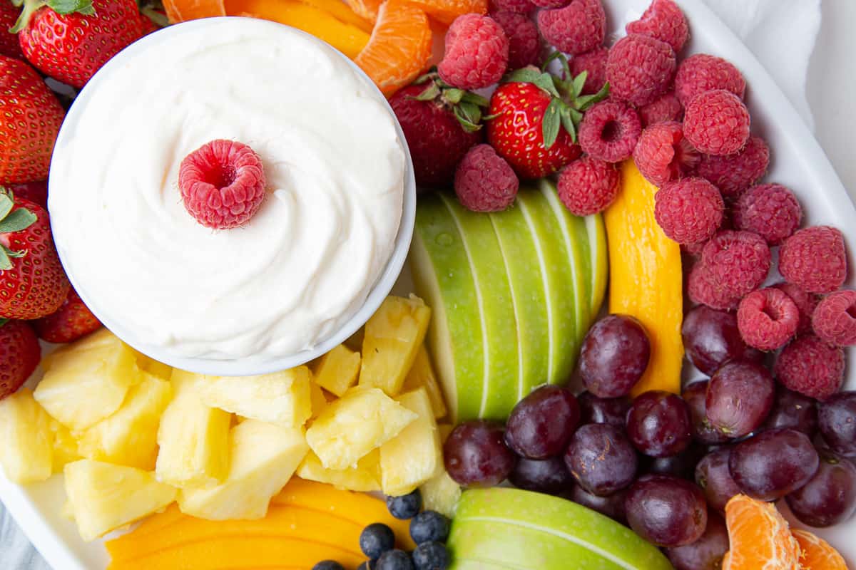 colorful fruit platter with a bowl of cream cheese fruit dip.