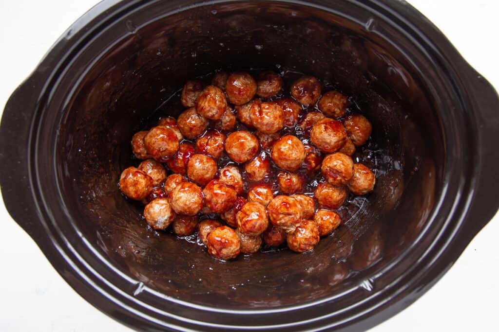 uncooked meatballs in a crockpot.