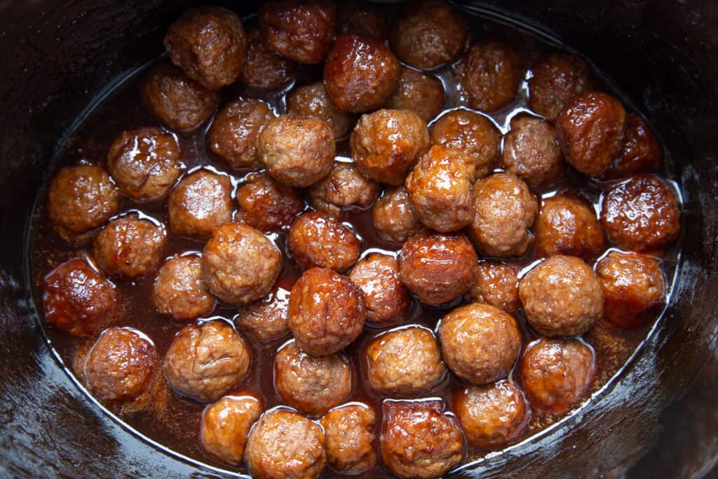 cooked meatballs covered in bbq sauce in a crockpot.