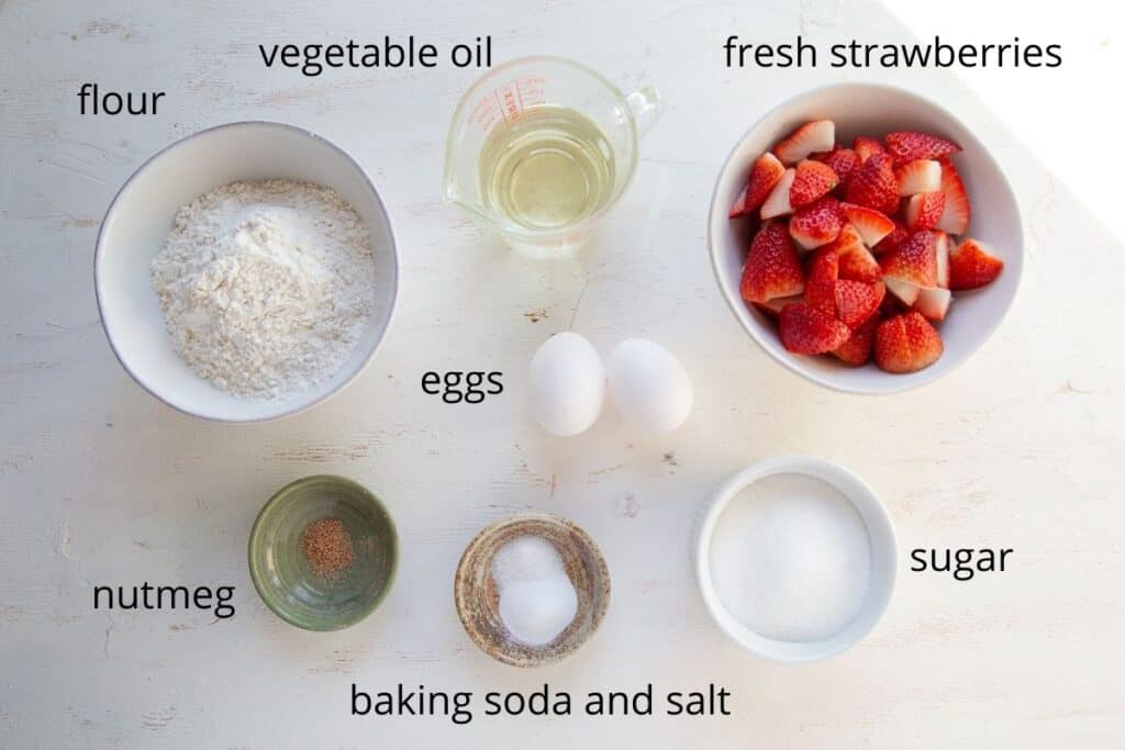 ingredients for strawberry bread on a white table.