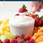 hand dipping a strawberry into fruit dip.