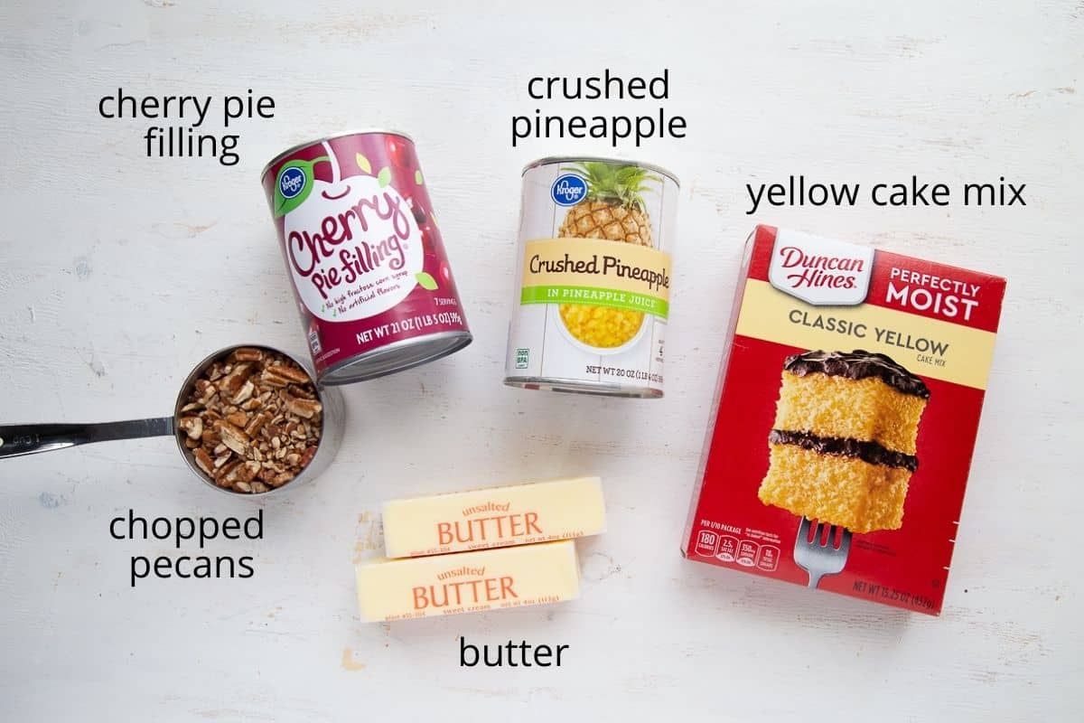 cherry dump cake ingredients on a white table.