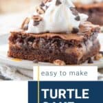 turtle cake slice topped with whipped cream.