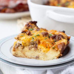 slice of sausage and egg casserole on a white plate.