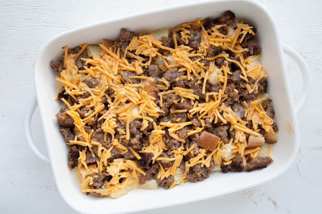 uncooked breakfast casserole in a white casserole dish.