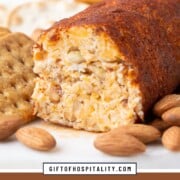 cheese log rolled in chili powder on a platter with crackers and almonds.