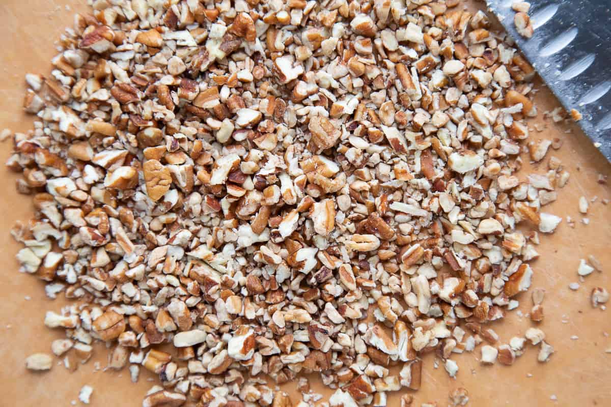 chopped pecans on a cutting board.