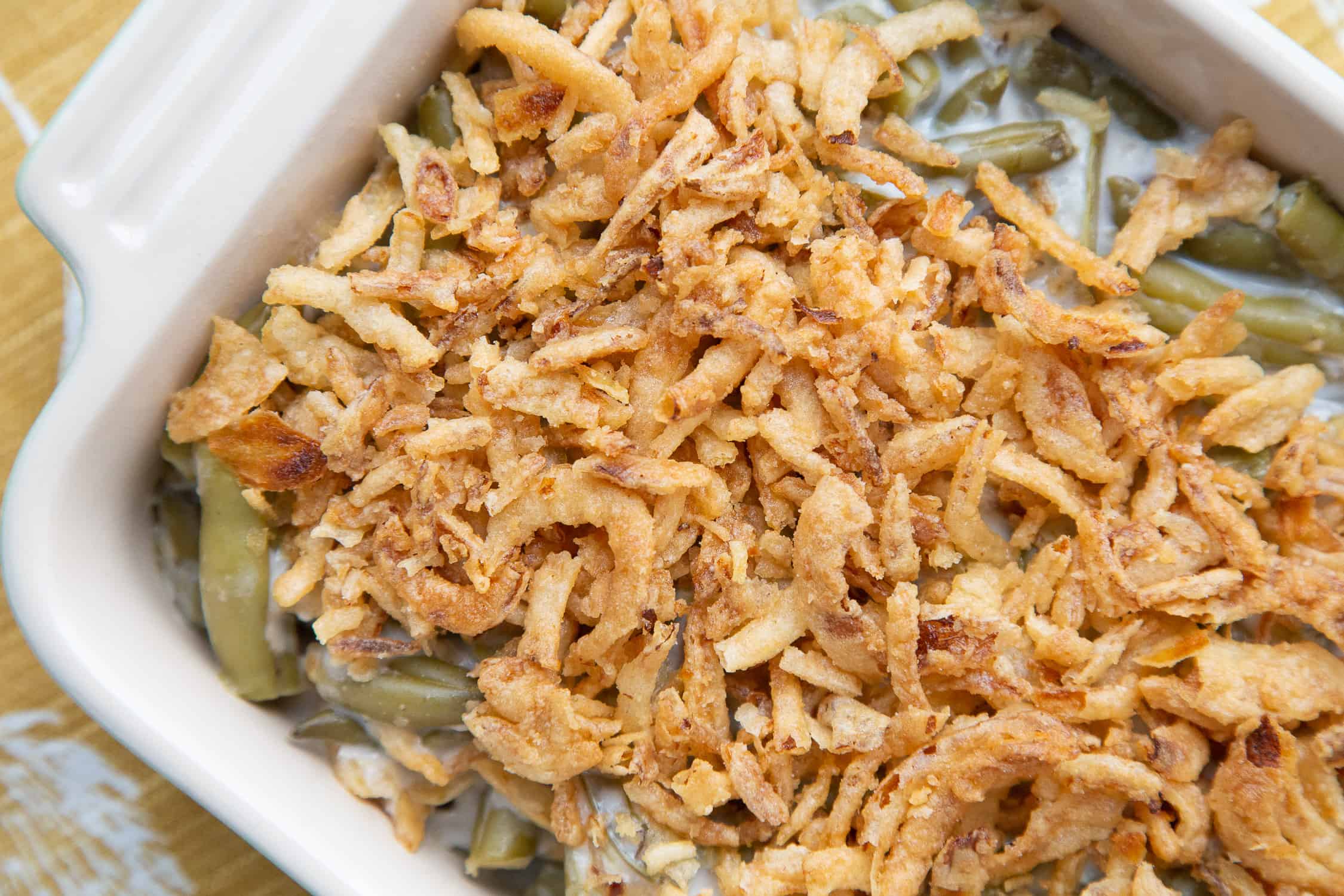 green bean casserole topped with fried onions in a casserole dish.