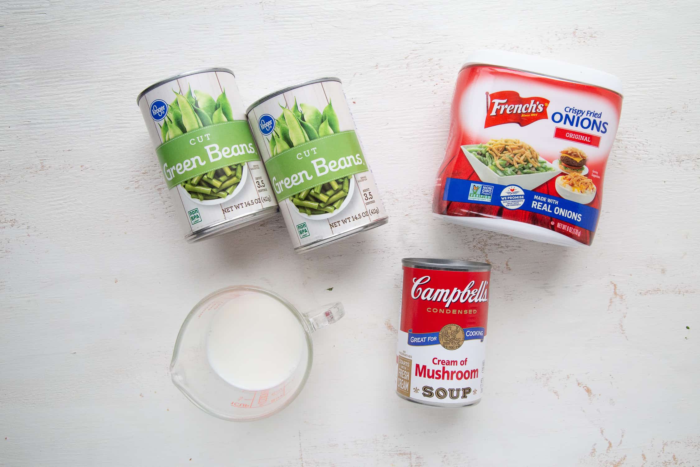 ingredients for green bean casserole on a white table.