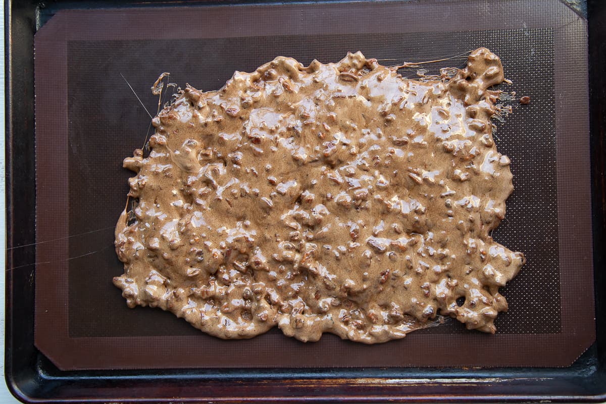 freshly cooked pecan brittle on a baking sheet.