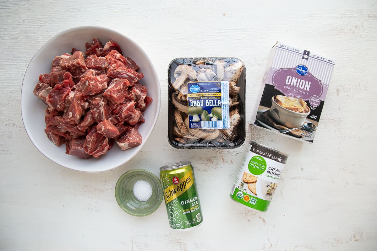 ingredients for beef stew with onion soup mix on a white table.