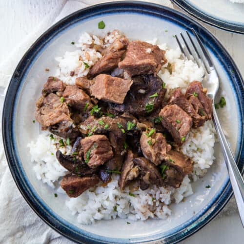 crockpot beef stew with onion soup mix on a bed of white rice with a fork.