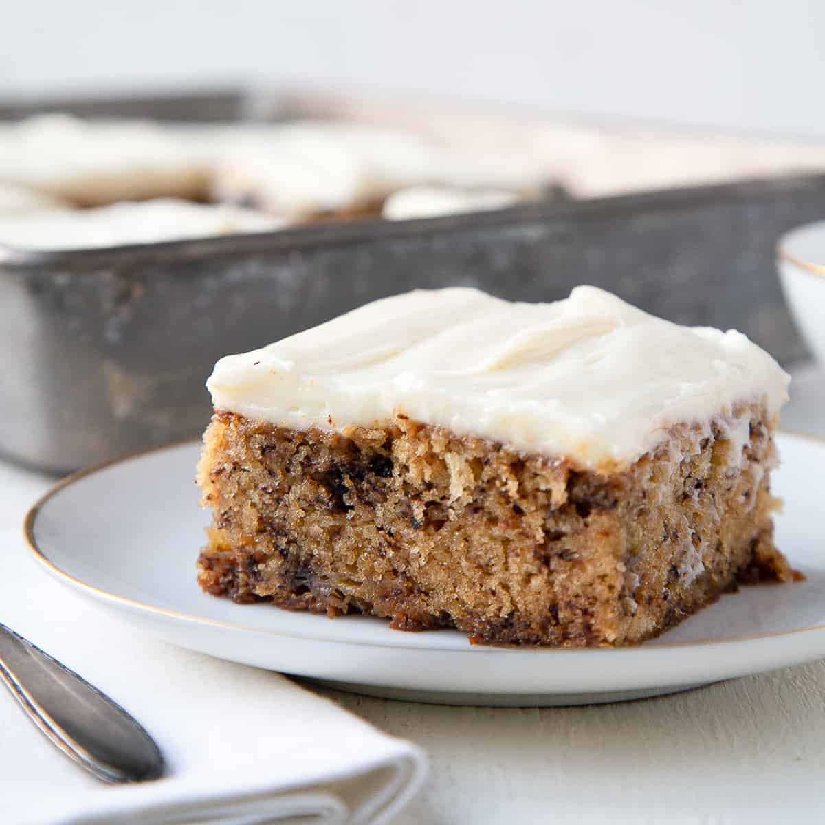 slice of old fashioned banana cake on a white plate.