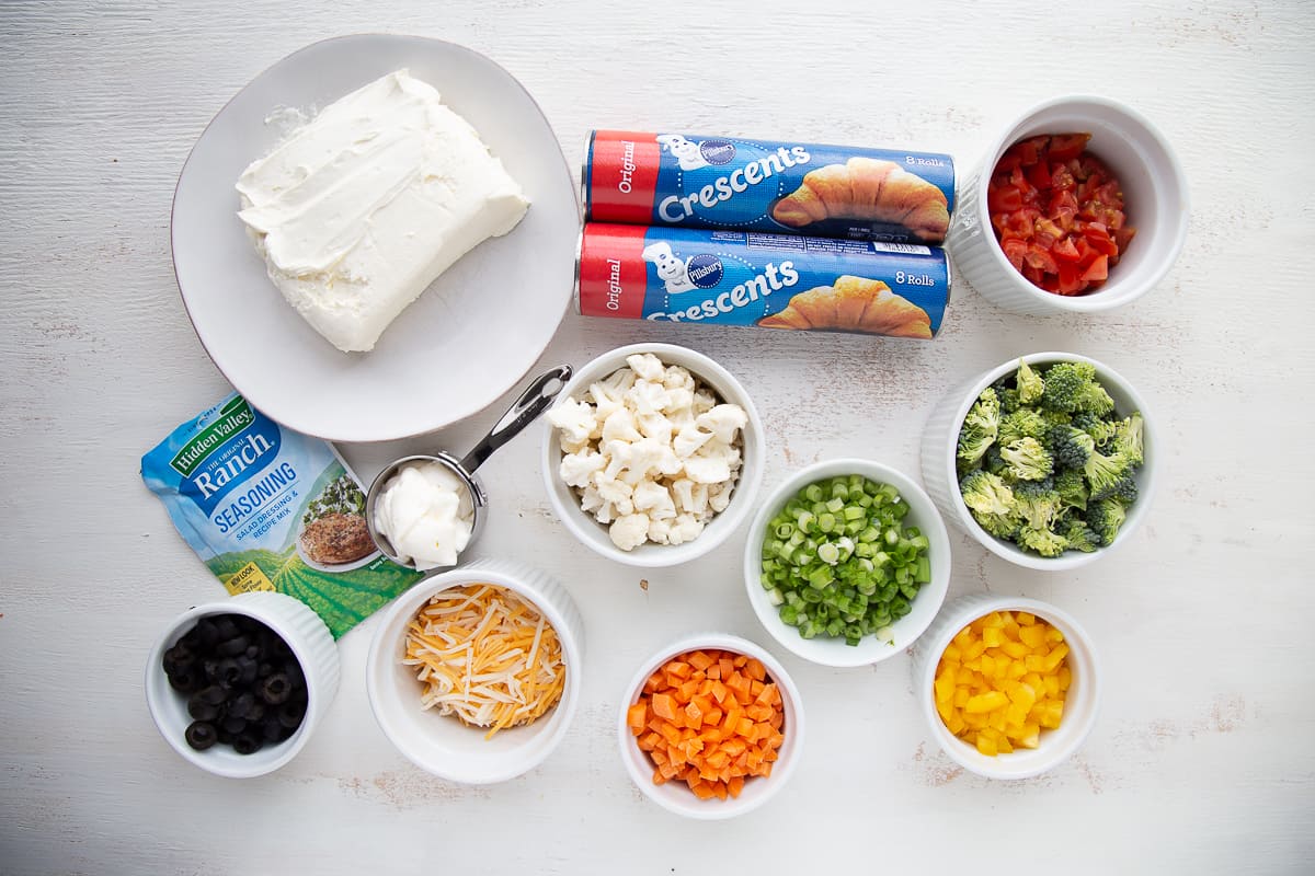 ingredients for crescent roll veggie pizza on a white table.