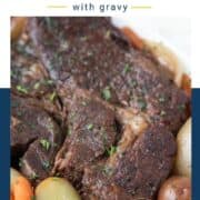 Crockpot Pot Roast on a white platter with potatoes and carrots.