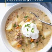 bowl of cheeseburger soup with sour cream and chives.