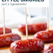 little smokies with grape jelly and chili sauce on toothpicks on a wooden board.