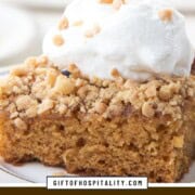 slice of cake topped with chopped heath bars and whipped cream.