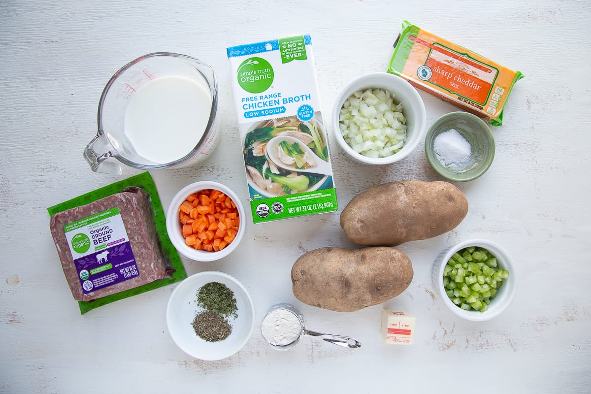 ground beef, potatoes, and other soup ingredients on a white table.