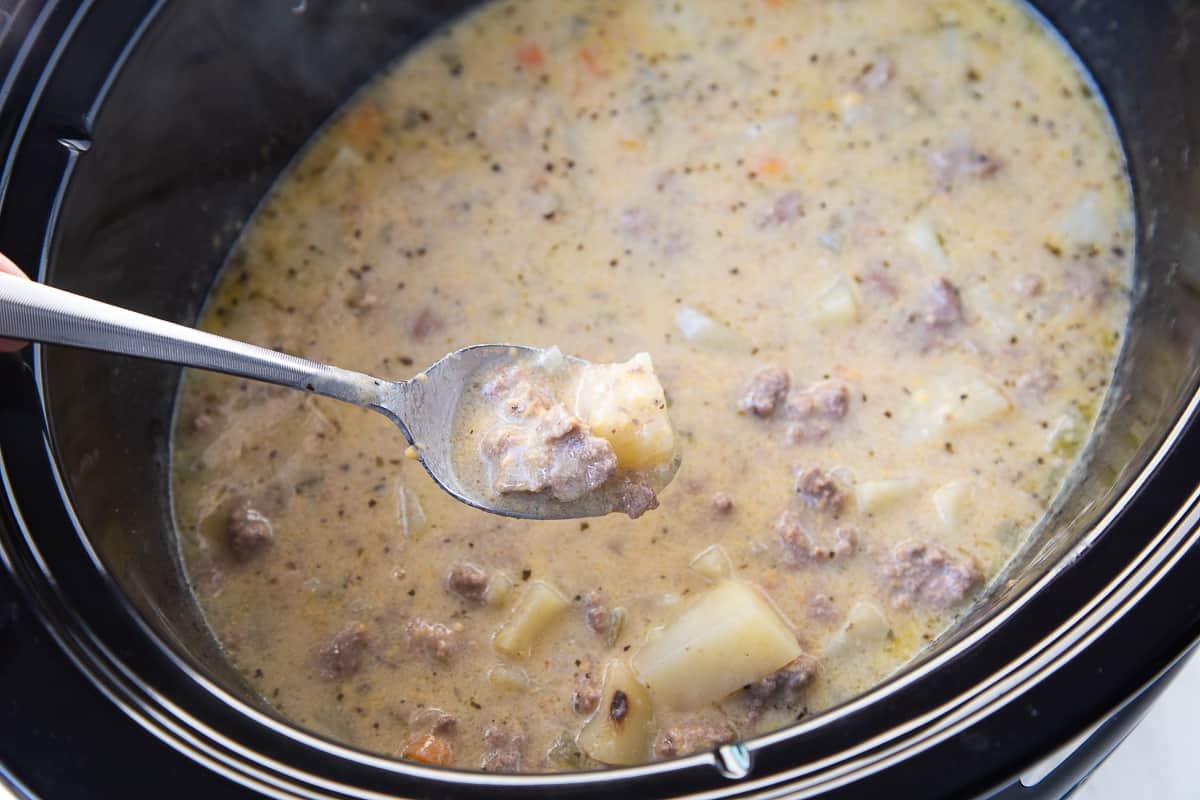 spoon with a scoop of cheeseburger soup on it. 