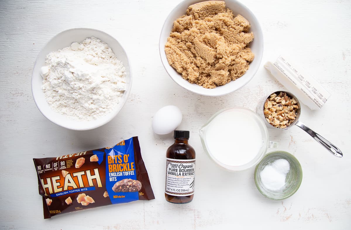 flour, sugar, vanilla, and other baking ingredients on a white table.