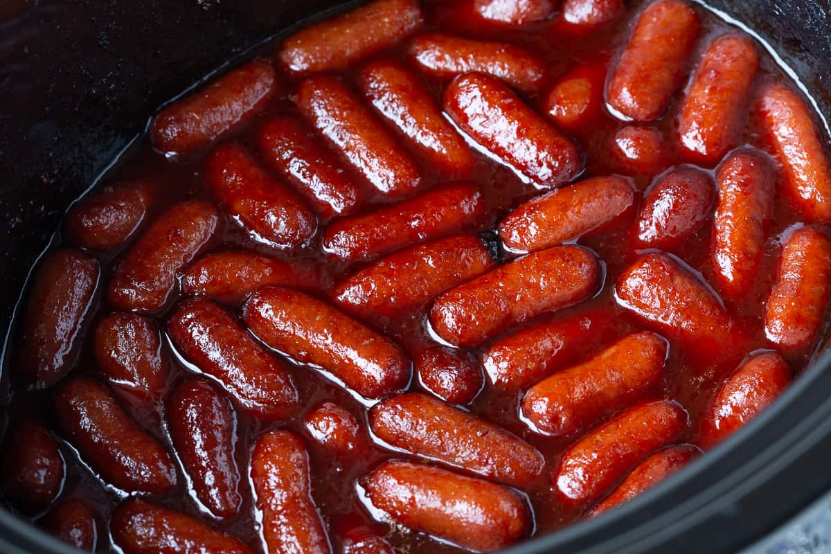 little smokies with chili sauce and grape jelly in a crockpot.