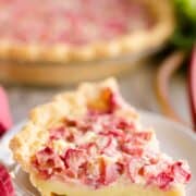 slice of rhubarb custard pie on a white plate.